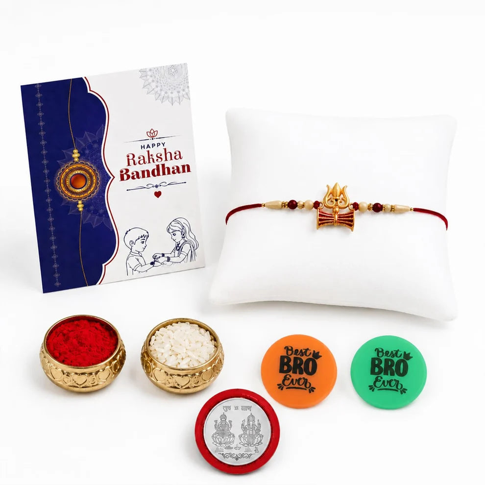 A Rakhi bandh gift set on a white background, featuring a red string bracelet with a gold Rakhi charm displayed on a white pillow, a greeting card, two small bowls of red and white powder, and three colorful circular stickers.