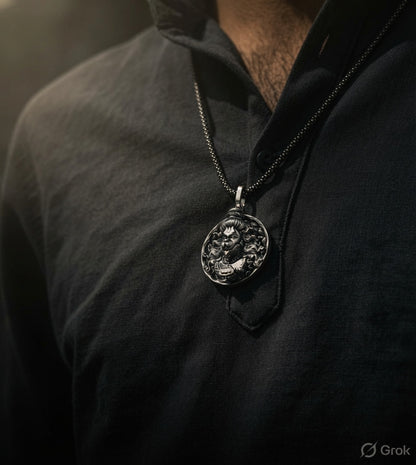 A close-up of a person wearing a detailed silver pendant necklace with a dragon design, hanging from a dark chain over a black shirt.